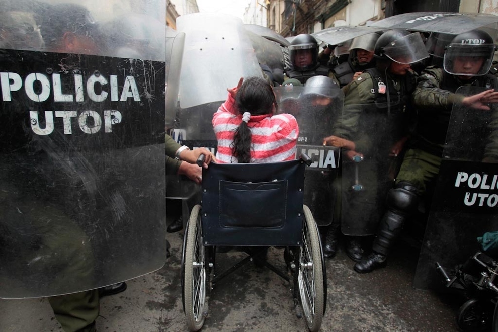 A Bolivian woman taking on a group of riot police