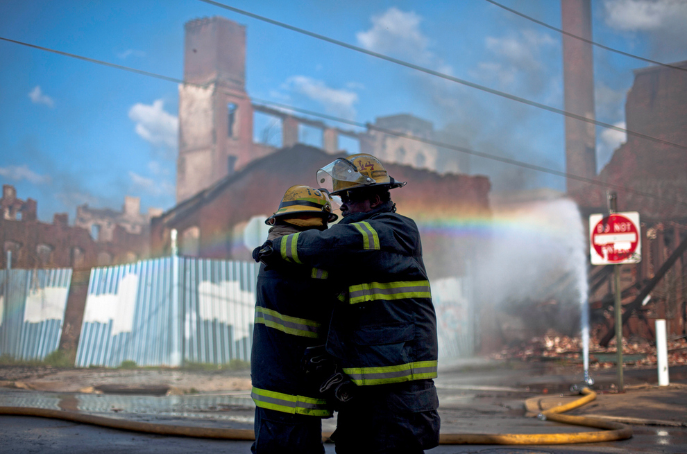 Two firefighters consoling each other after finding out two of their comrades were killed